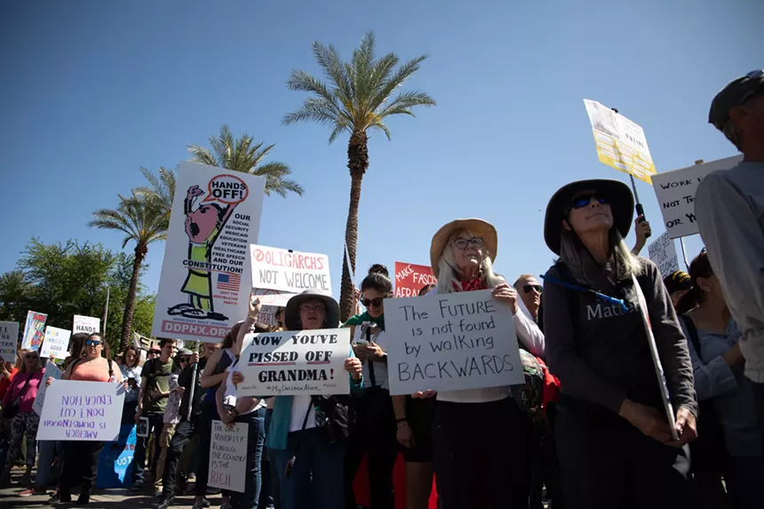 protesters hold signs. one says "now you've pissed off grandma"