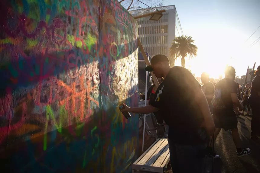 a man spraypaints a wall