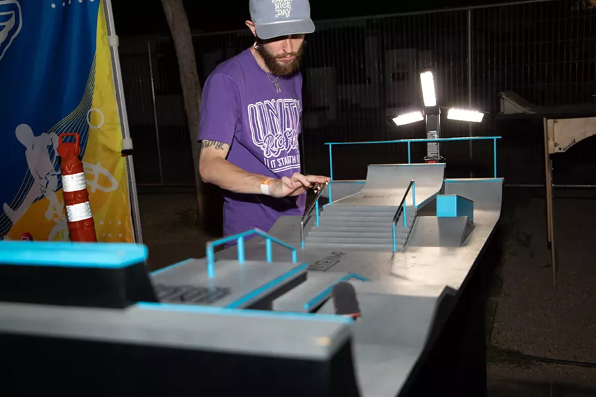 a man finger boards on a miniature skate park