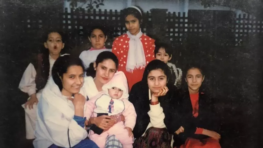 a family poses for a photo in the 1990s