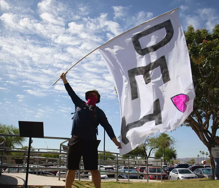 a man waves a big "DEI" flag
