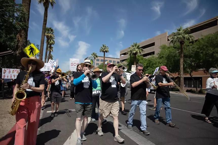 protesters play horns on a march