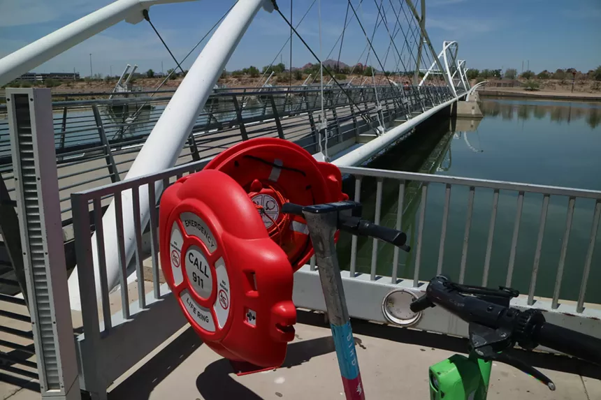 a red case near a lake that holds a flotation ring