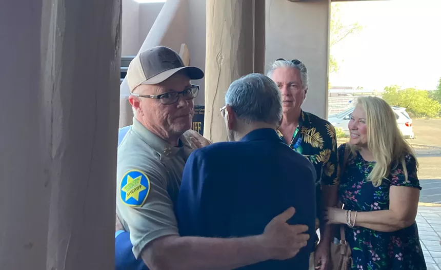jerry sheridan stares annoyedly at the camera as he hugs joe arpaio