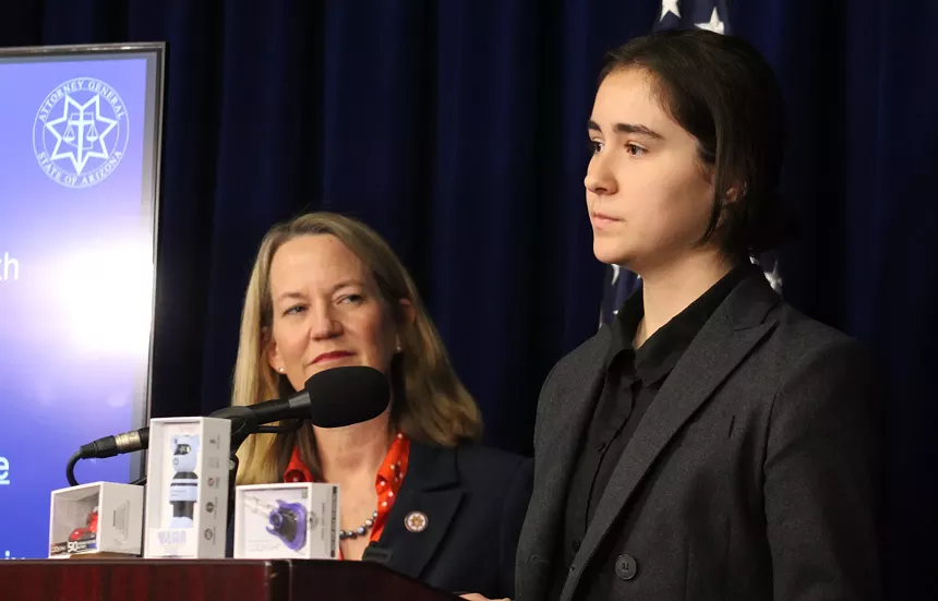 kris mayes looks at a teenage girl at a press conference