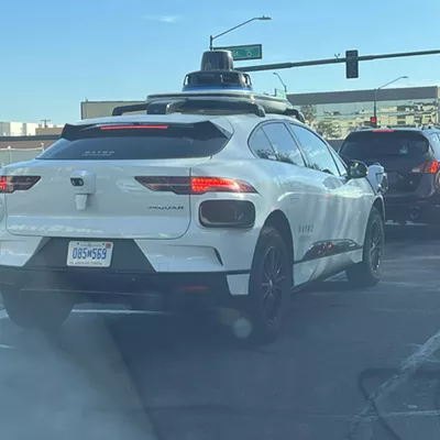 A Waymo vehicle drives down McDowell Road in central Phoenix.