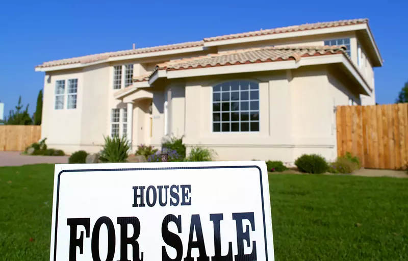 Image: a house with a for sale sign out front