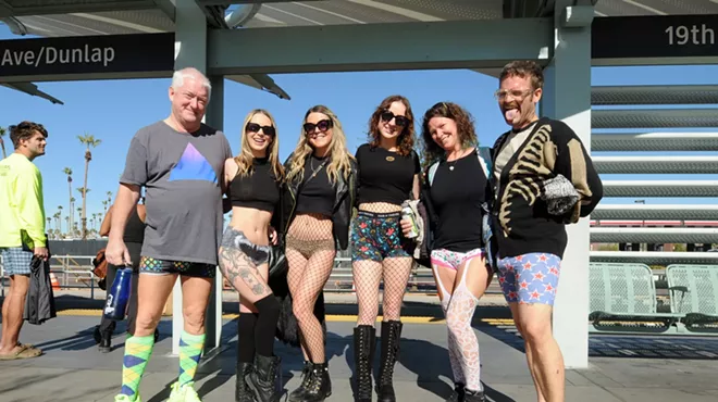 People wearing no pants at a light rail station.