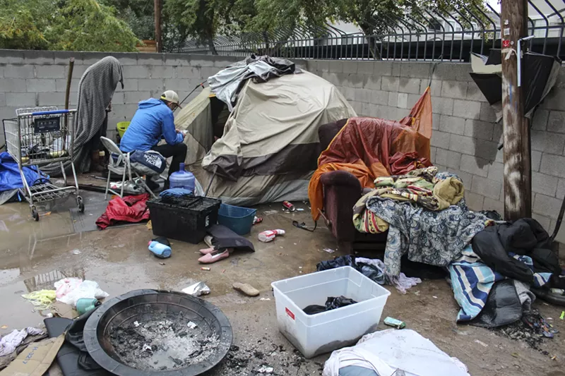 Image: Brian Gruters talks to people living in a dirt lot.