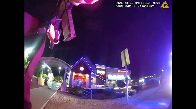Image: body-cam footage of a police officer pointing a gun at a man at night
