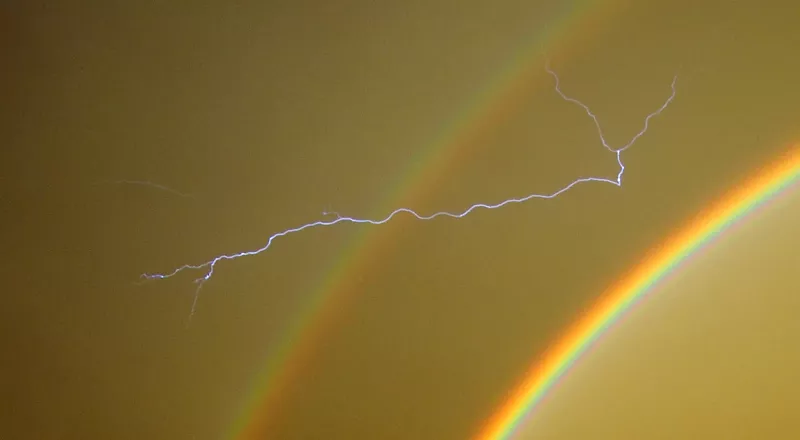 Image: a lightning bolt streaks across a rainbow