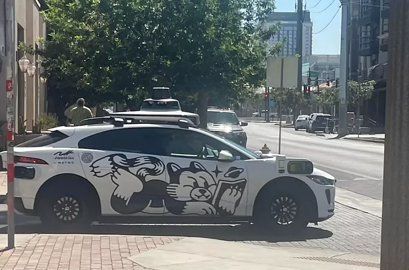 Image: a waymo driverless car with a cartoon cat on the side