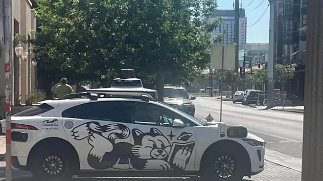 a waymo driverless car with a cartoon cat on the side