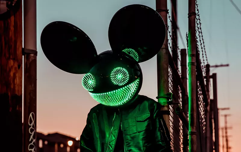 Image: A man wearing an illuminated mouse mask.