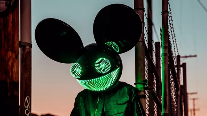 A man wearing an illuminated mouse mask.