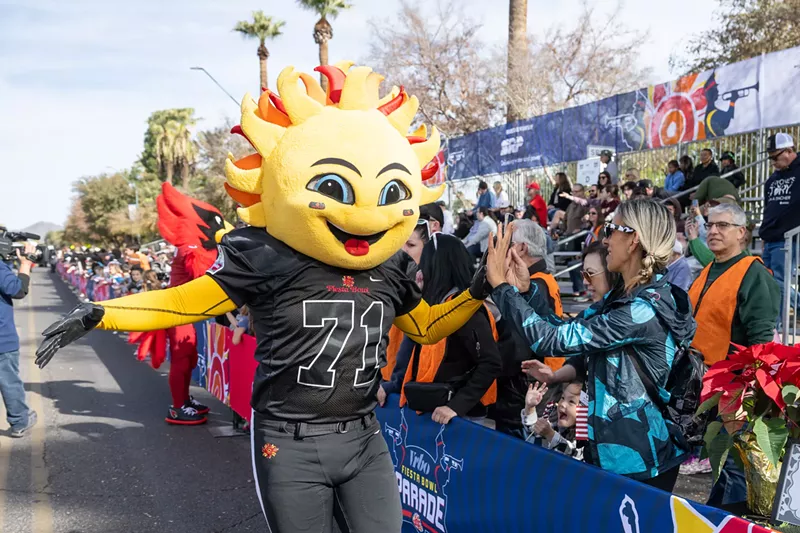 Image: A person in a costume interacting with the public.