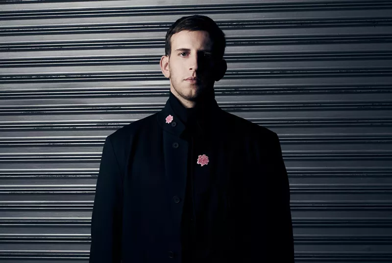 Image: A man standing in front of a wall.